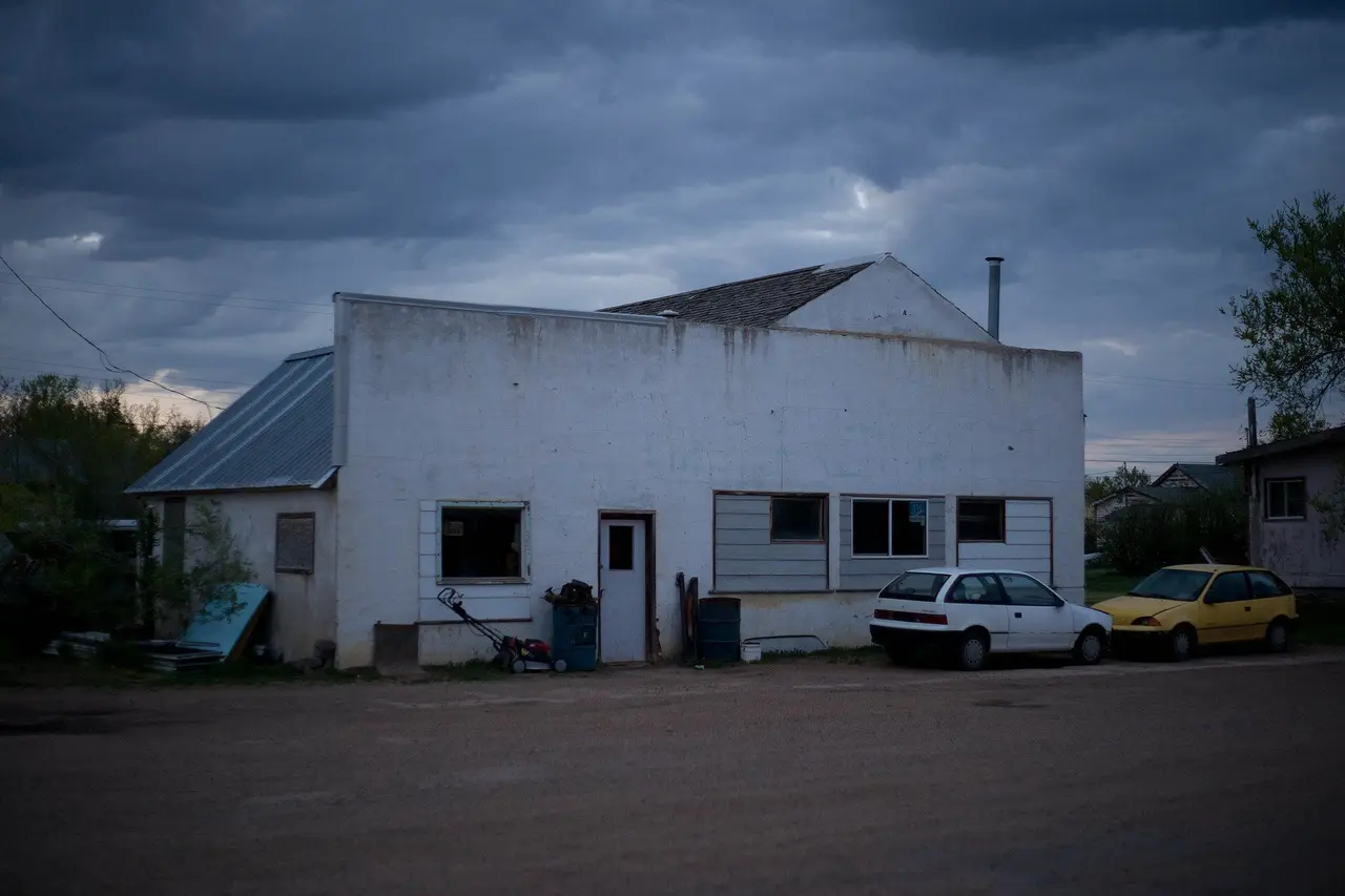 Old white building on a gravel street at dusk, 2009