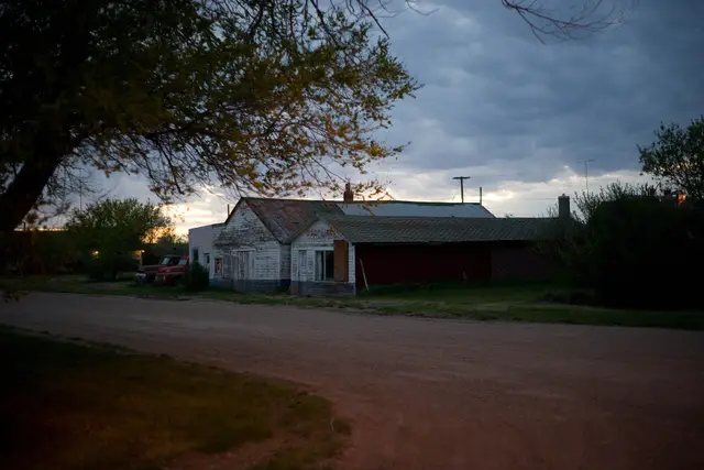 Old hardware store on a gravel street at dusk